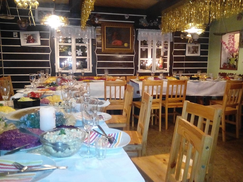 Prostřené stoly ve vyzdobené restauraci ve stylu roubenky