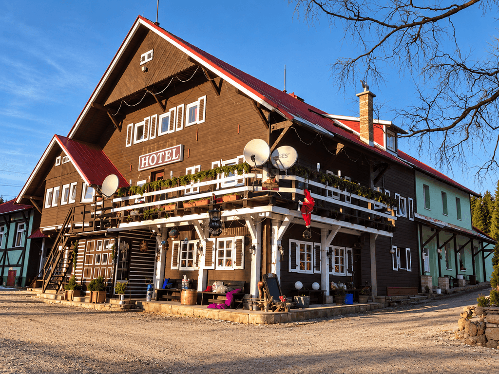 Holzfassade des Hotels mit Balkonen und dem Schriftzug HOTEL
